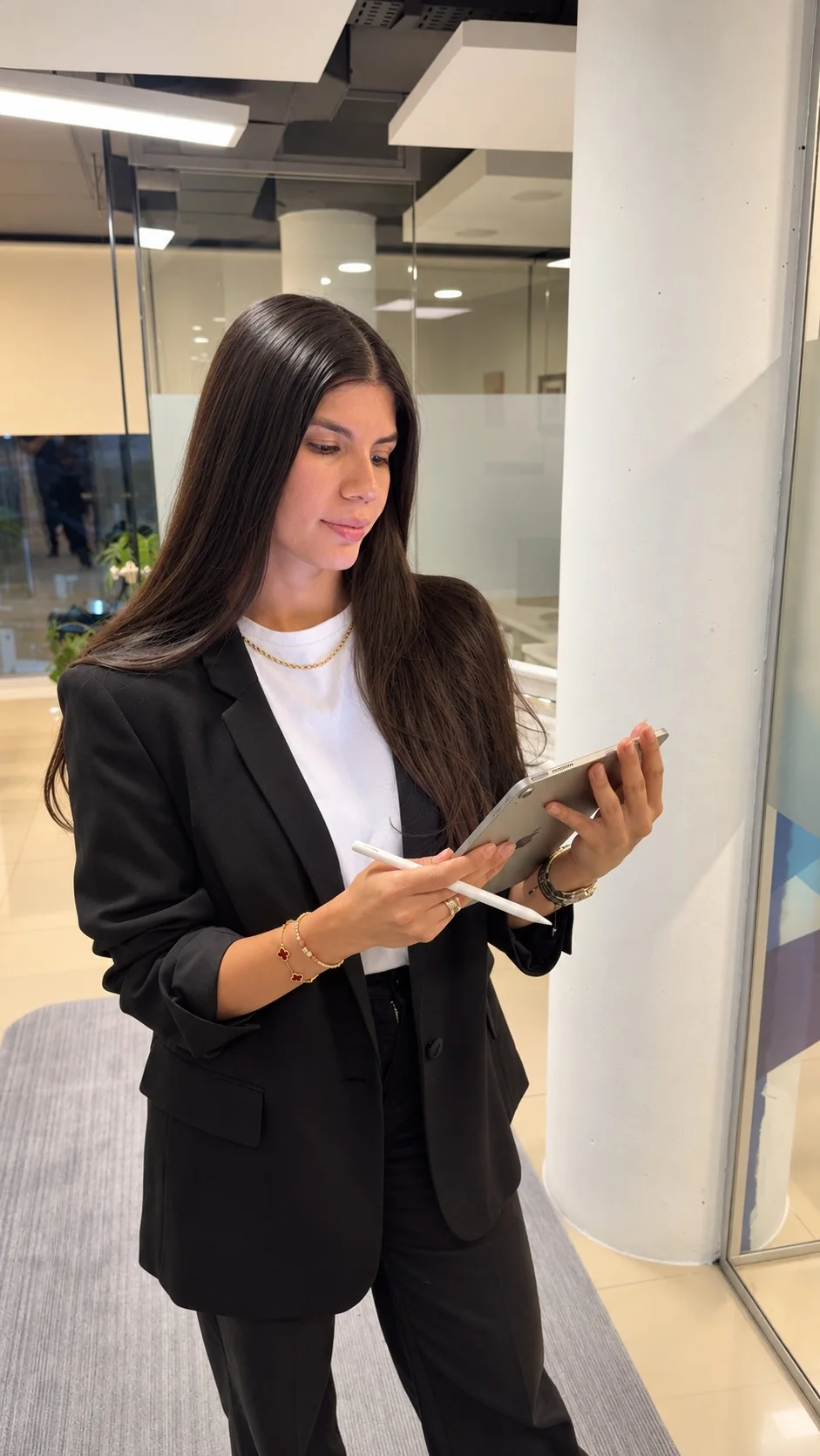 Shir Ladino de pie en la oficina, revisando una tablet